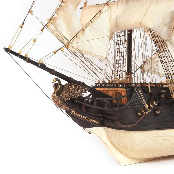 Close-up of the OcCre Black Swan 12012 pirate ship model showing the bow, bowsprit, detailed sails and intricate sailing rigging.