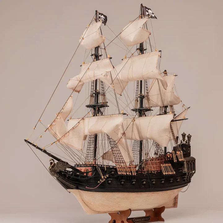OcCre Black Swan 12012 wooden pirate ship model displayed with its complete sailing rig, dark hull, decorative stern and detailed deck structures.