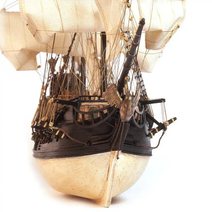Rear view of the completed OcCre Black Swan 12012 wooden pirate ship model showing its decorated stern, sailing rig and detailed wooden structures.