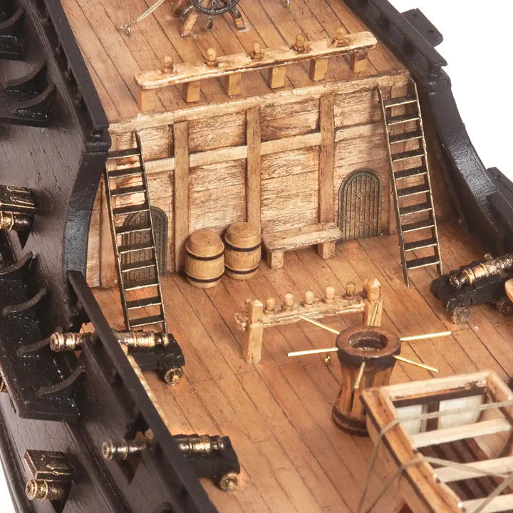Close-up of the OcCre Black Swan 12012 pirate ship model showing detailed wooden deck planking, stairways, railings and nautical fittings.
