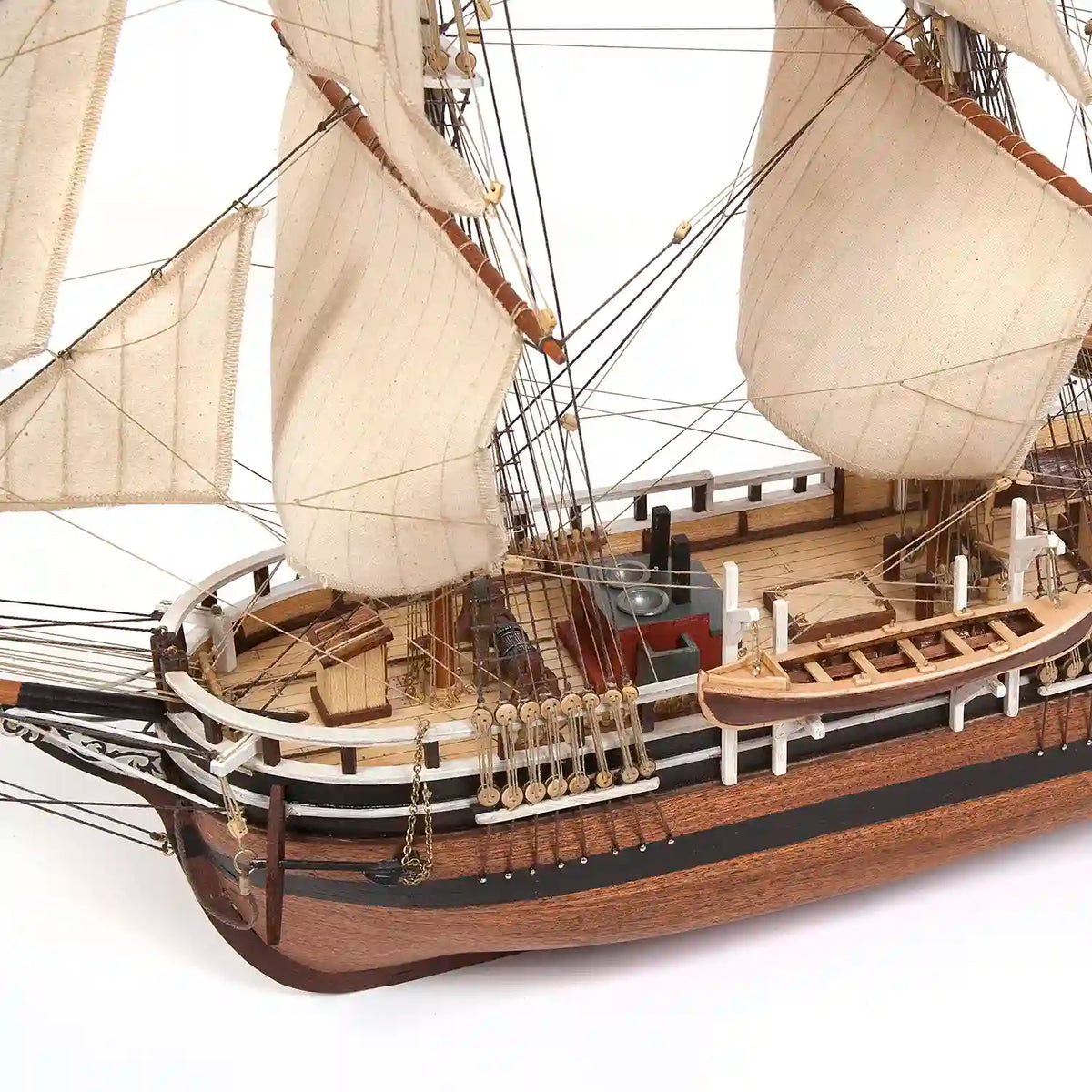 Close-up of OcCre Essex 12006 wooden whaling ship model showing detailed hull construction, deck fittings, masts, sails and traditional rigging.